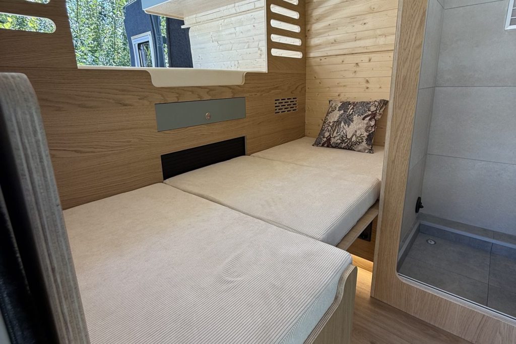Lit et banquette convertible en bois dans un van aménagé par Vanatipik, Liège