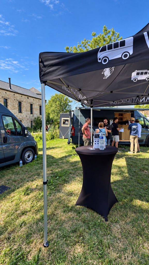 Stand Vanatipik au Festivan 2026 à Gembloux, visiteurs en discussion devant un van aménagé