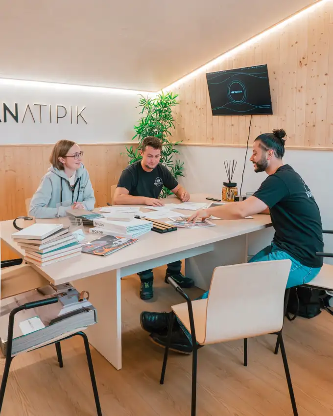 Réunion de conception d'un projet de van aménagé dans la salle client de l'atelier Vanatipik à Ans